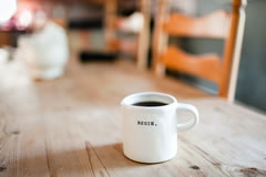 Coffee mug on a table, with the legend 'begin' across its front