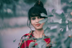Lady looking out through foliage 