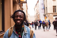 Man on the street with headphones, smiling